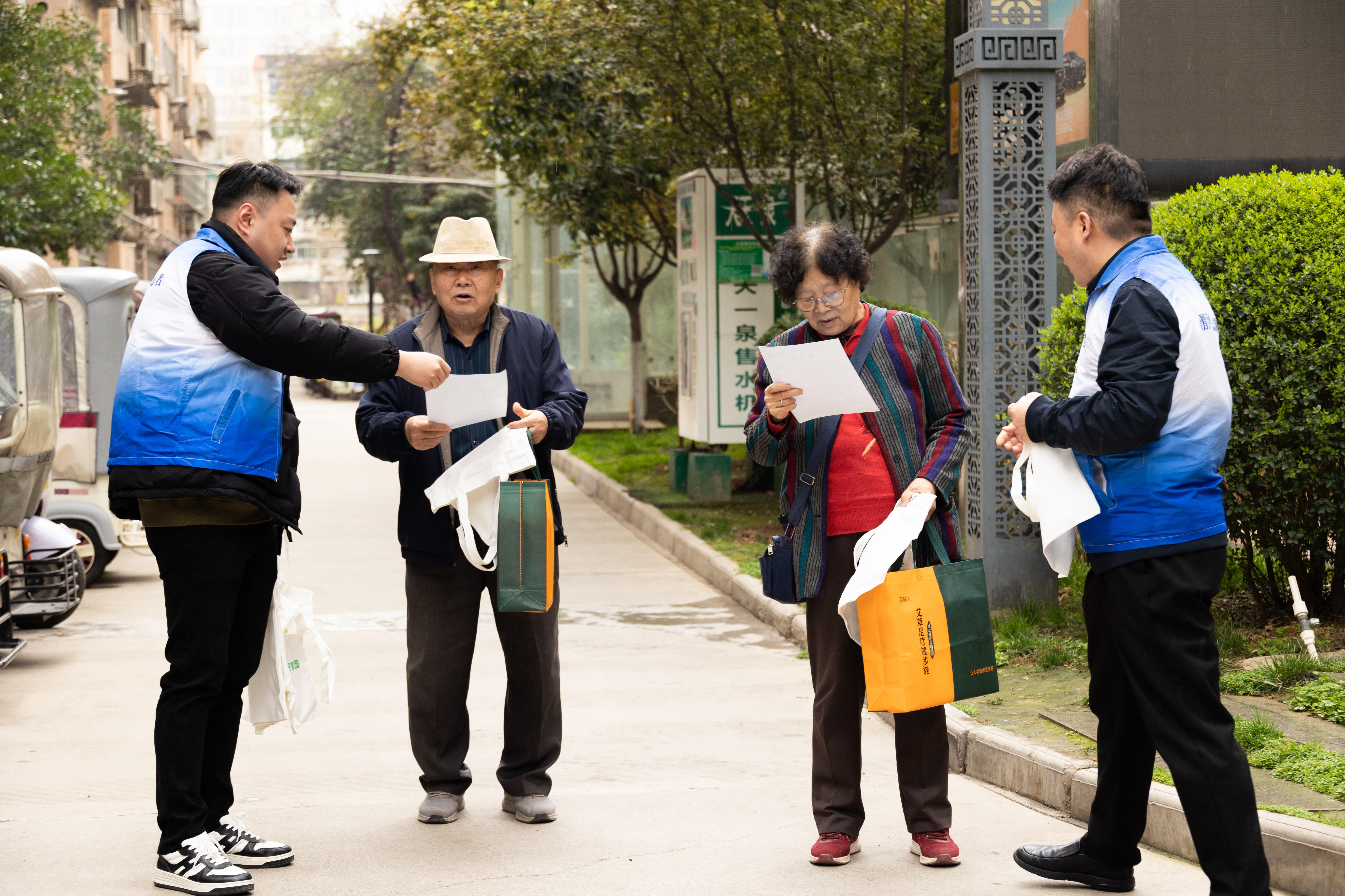 志愿者在红缨社区向过往居民发放节水宣传倡议书.jpg